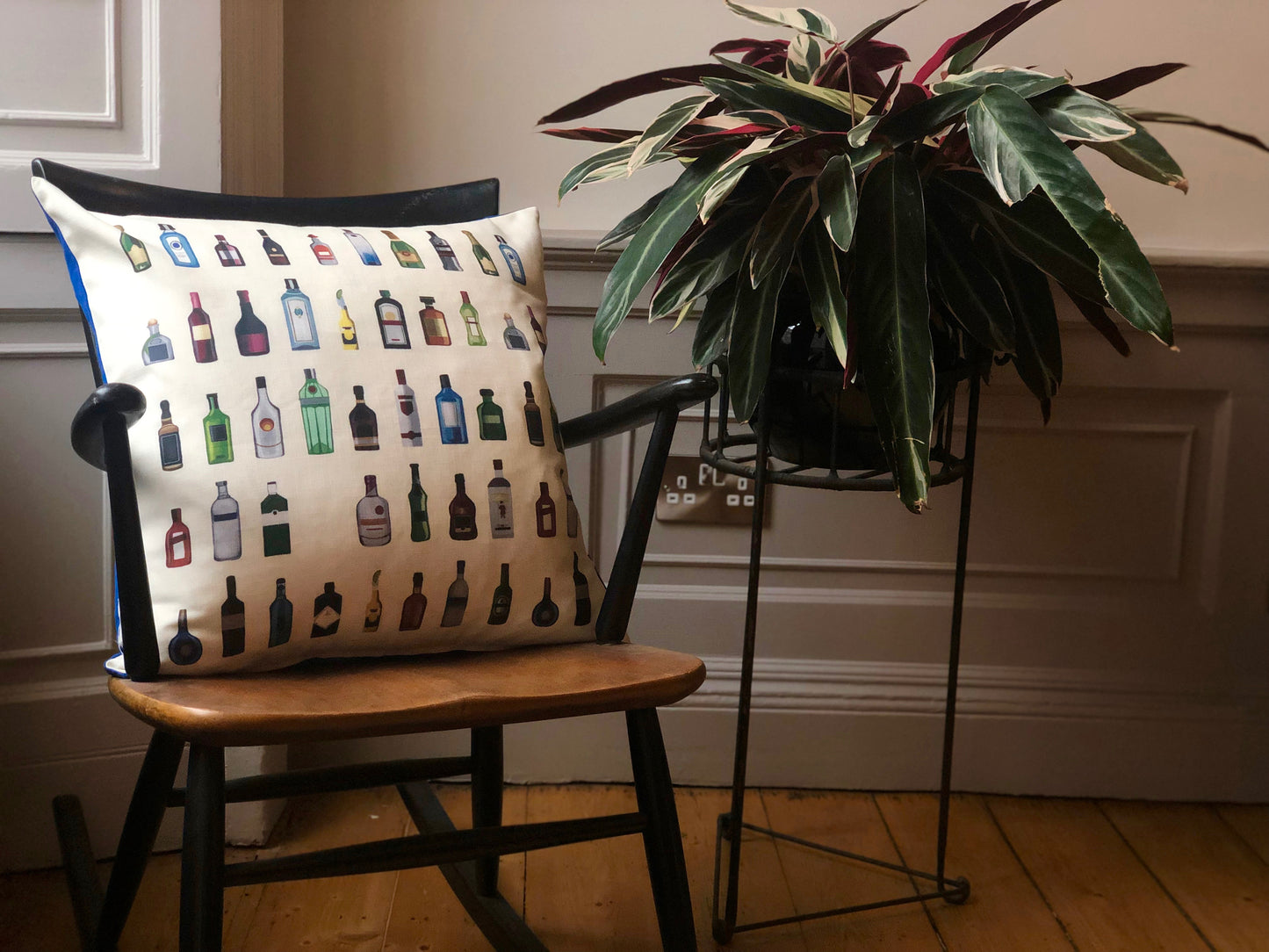 Alcohol bottle inspired cushion on chair 